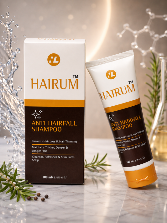 HAIRUM Anti Hairfall Shampoo packaging on a marble surface with decorative elements.